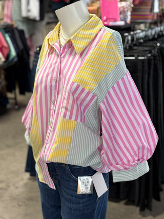 Mannequin wearing a colorful striped shirt with a blurred store background
